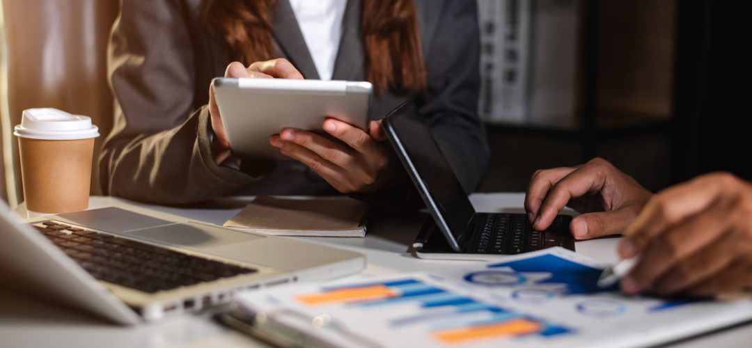 Business People Talking Discussing with financial document data charts and graphs Team business meeting with smart phone and laptop and digital tablet computer
