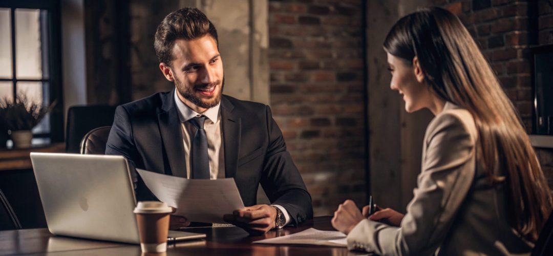 Young bank manager going through agreement with her client during meeting in office