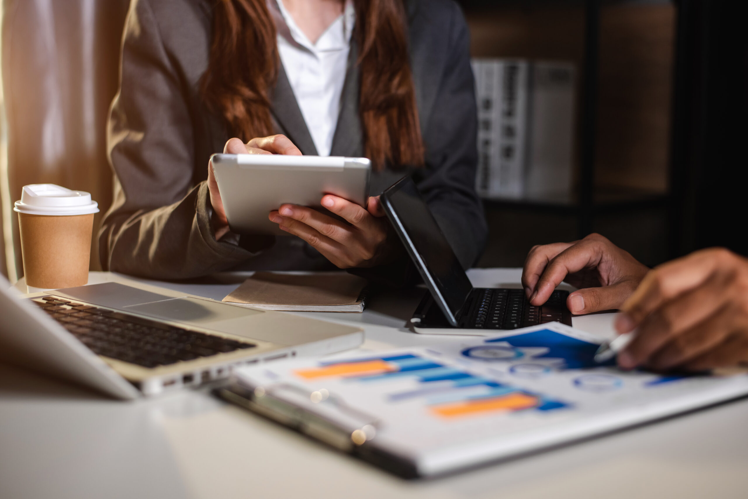 Business People Talking Discussing with financial document data charts and graphs Team business meeting with smart phone and laptop and digital tablet computer